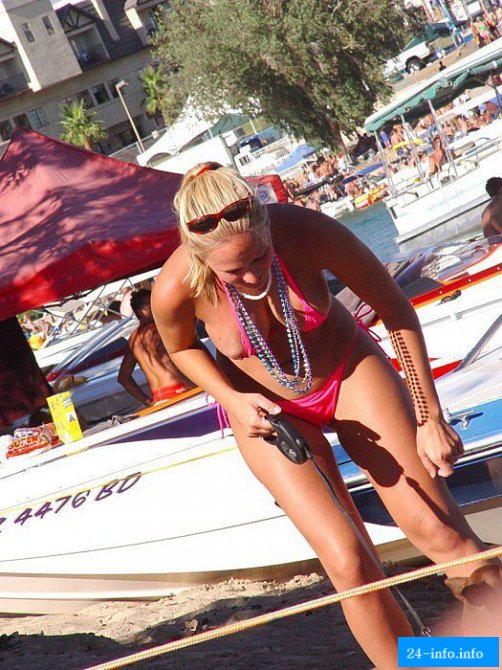 Девушка в розовом бикини выгуливает собачку