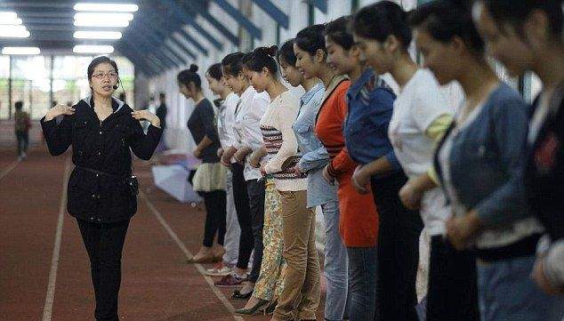 Китайские девушки отрабатывают улыбку, кусая палочки для еды Китайские девушки отрабатывают улыбку, кусая палочки для еды