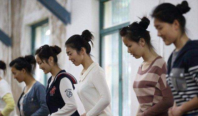 Китайские девушки отрабатывают улыбку, кусая палочки для еды Китайские девушки отрабатывают улыбку, кусая палочки для еды