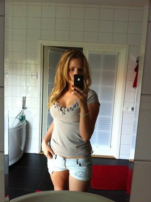 Девушки фотографируют свое отражение в зеркале