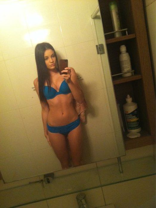 Девушки фотографируют свое отражение в зеркале