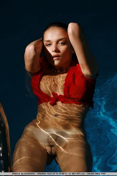 Обнаженная брюнетка купается в бассейне