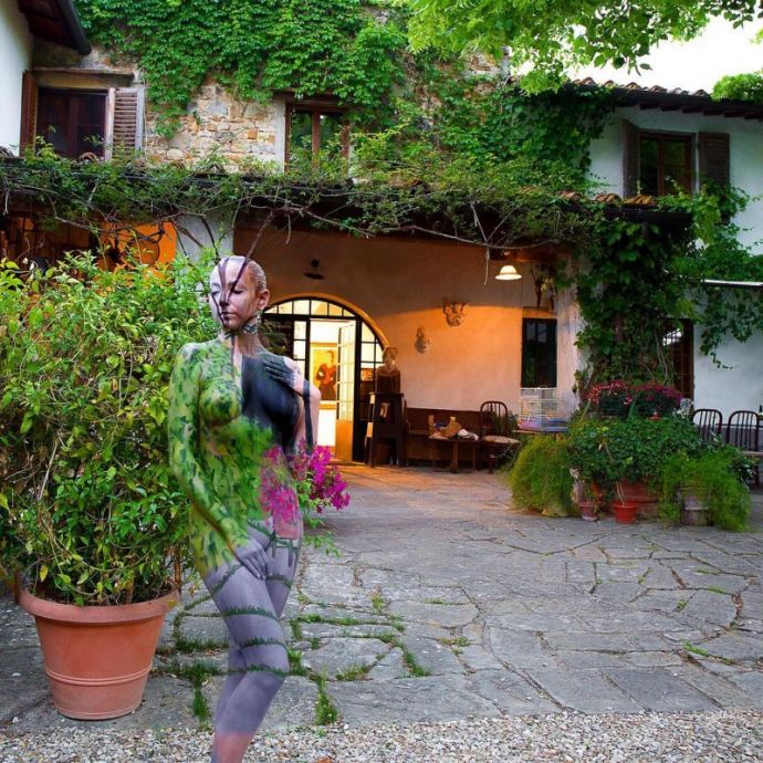 Обнаженные женщины, растворенные в окружении с помощью боди-арта