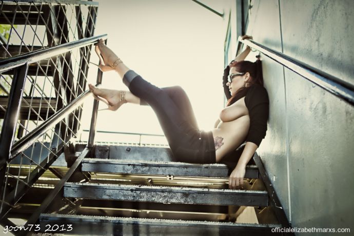 Гламурная девка в джинсах показывает висячую грудь