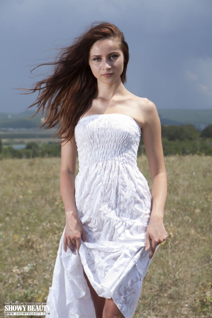 Красивая сучка в поле сексуально снимает платье