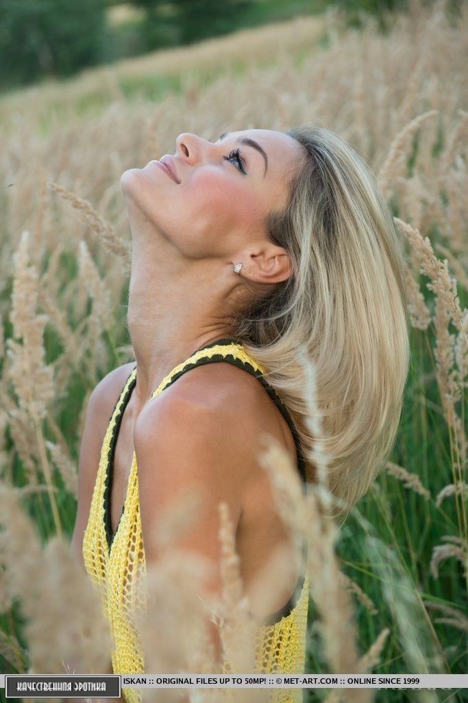 Блондинка на поляне начинает красиво раздеваться