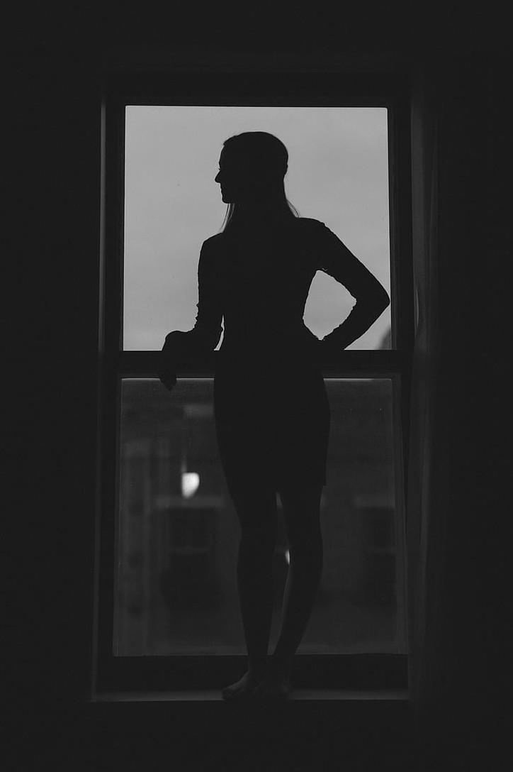 Силуэт девушки в темноте у окна