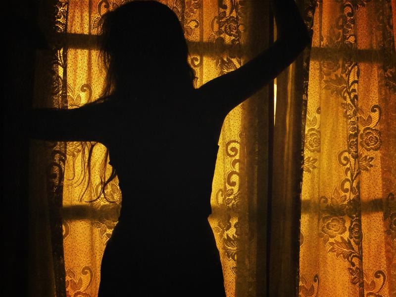 Тень девушки на стене от солнца